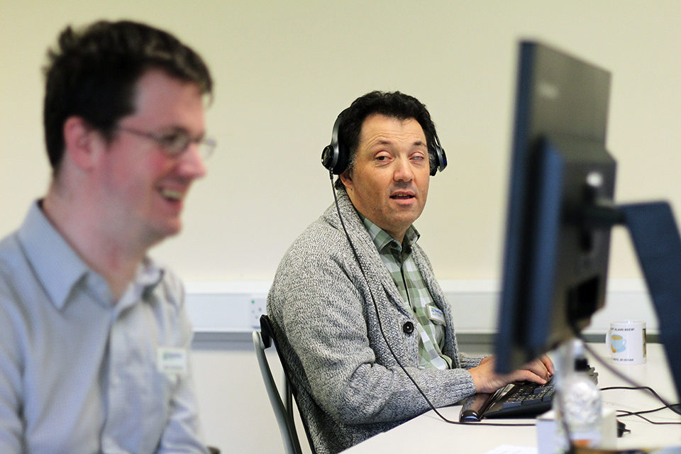 Alan Sleat at his computer with headphones on