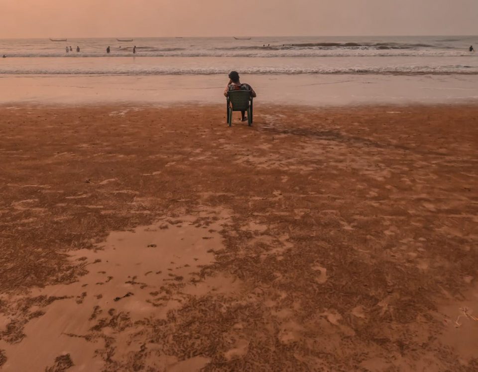a man sat in a wheelchair watching the tide come in