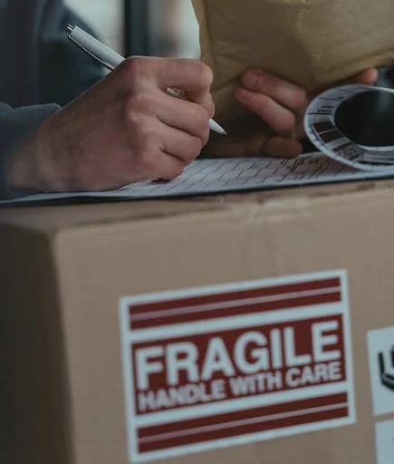 someone completing a form to receive a large parcel