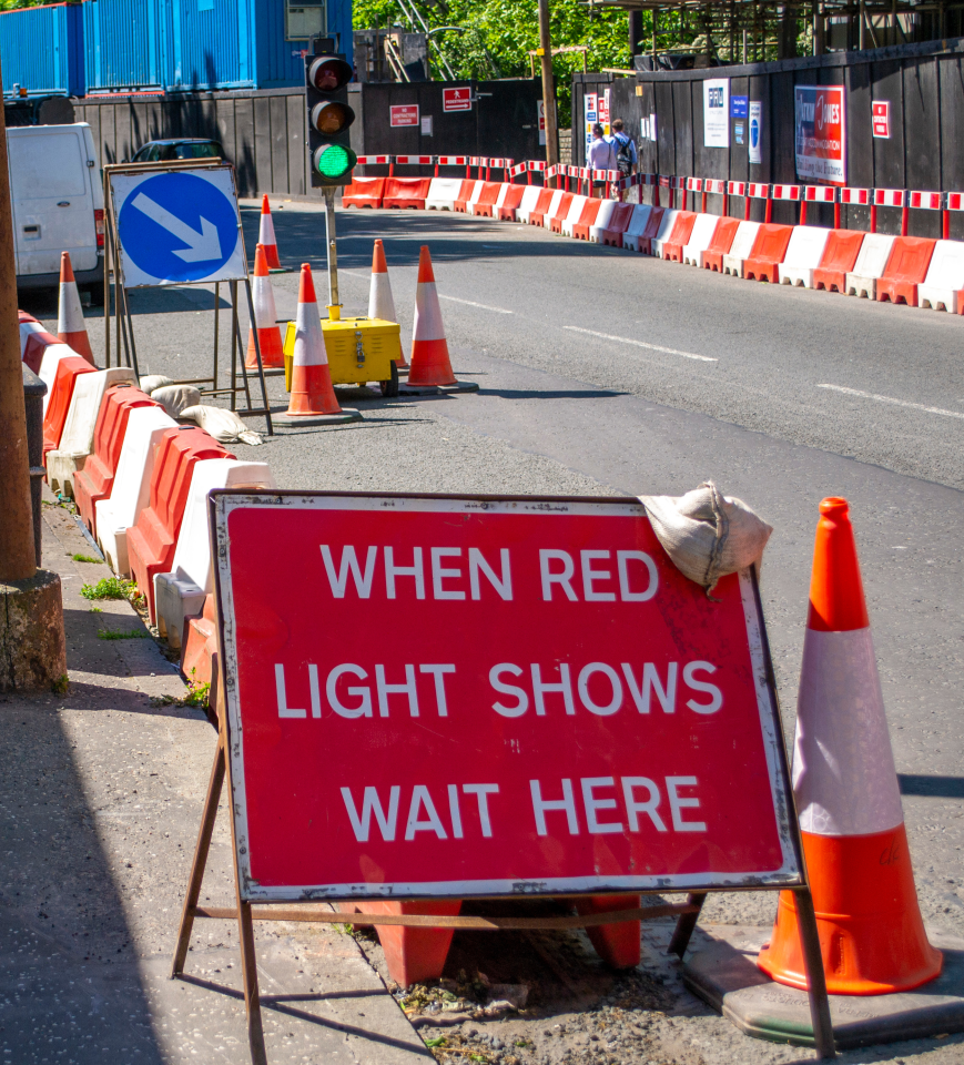 temporary traffic lights with a sign reading "when red light shows wait here"